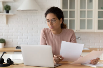 woman comparing notes in her home kitchen