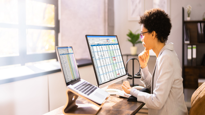 young woman with short hair looking at spreadsheets on the computer