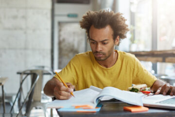 concentrated grad student taking dissertation notes