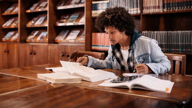 grad student comparing notes in the library