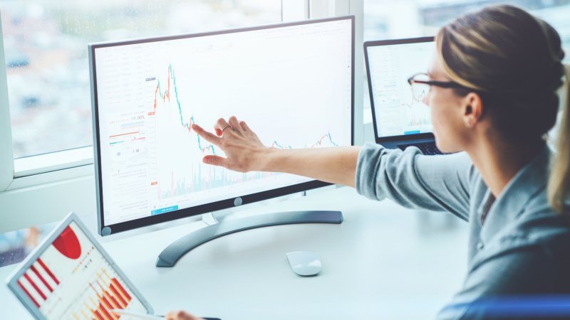 woman pointing at graph on computer