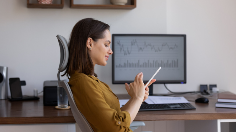 woman using her phone in front of her desk