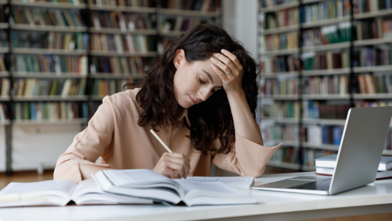 young woman tired of studying in front of laptop