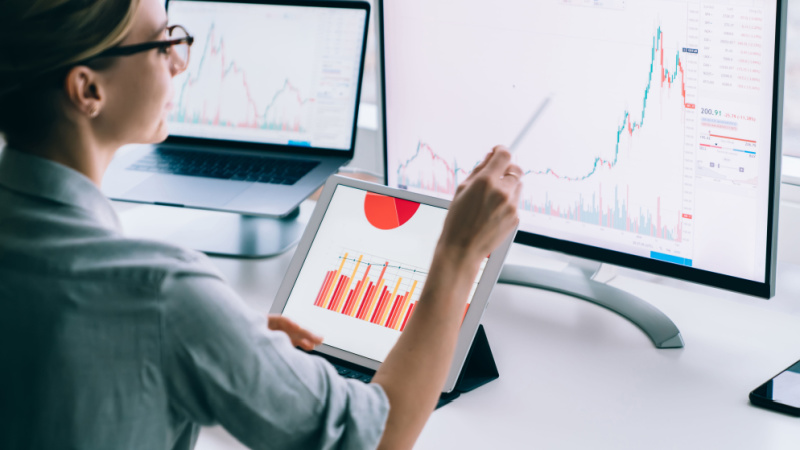 woman with glasses analyzing statistical data on her computer